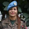 A major Ahlem Douzi, da Tunísia, vestindo uniforme militar e boina azul, posa para um retrato.