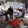 Жители Рафаха ищут уцелевшие вещи на развалинах своего дома.