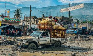 A vehicle ploughs through mud after floodwaters receded.