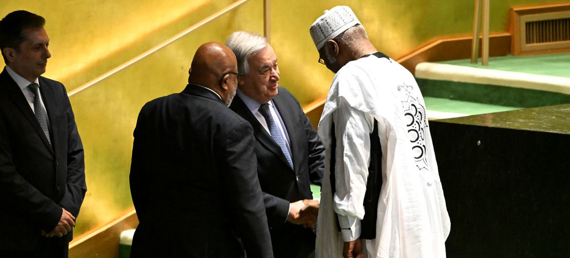 Secretary-General António Guterres (centre) congratulates Philemon Yang of Cameroon, the President-elect of the 79th session of the UN General Assembly.