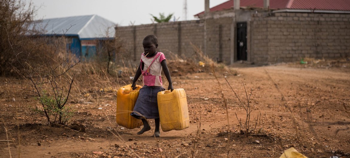 Uma criança carrega galões vazios para encher com água de uma torneira próxima que fornece água não tratada do rio Nilo, em Juba, no Sudão do Sul.