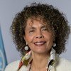 Cristina Duarte, Conselheira Especial para a África do Secretário-Geral das Nações Unidas , sorri durante uma sessão de fotos com a bandeira da ONU ao fundo.