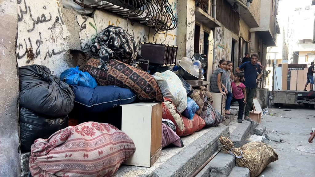 La familia Abu Amer Al-Sharif, residente de la ciudad de Gaza, retira sus pertenencias y enseres domésticos de su hogar.