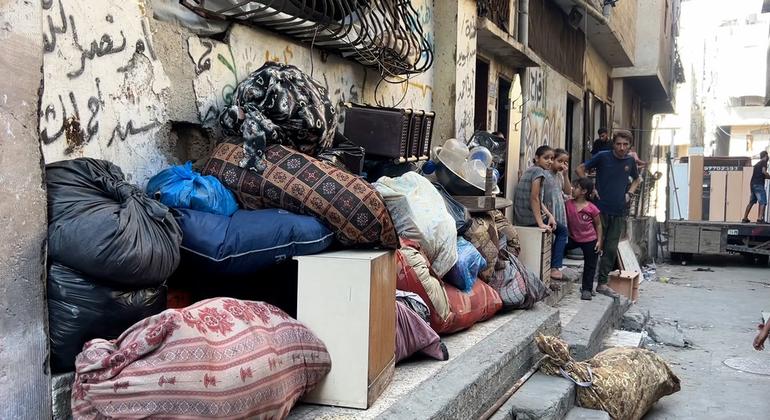 La familia Abu Amer Al-Sharif de la ciudad de Gaza saca sus pertenencias y enseres de su casa.