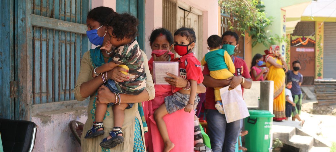Des parents et des accompagnateurs font la queue avec leurs enfants dans un centre de vaccination au Népal.