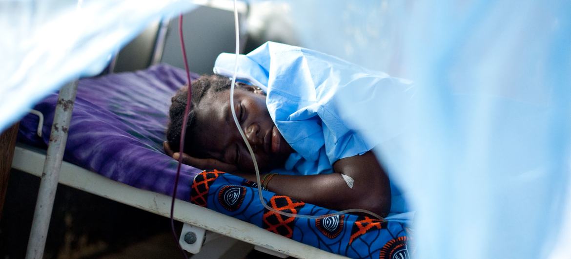 A woman whose baby was stillborn after a 10-hour labour sleeps in the maternity ward of a hospital in Sierra Leone.