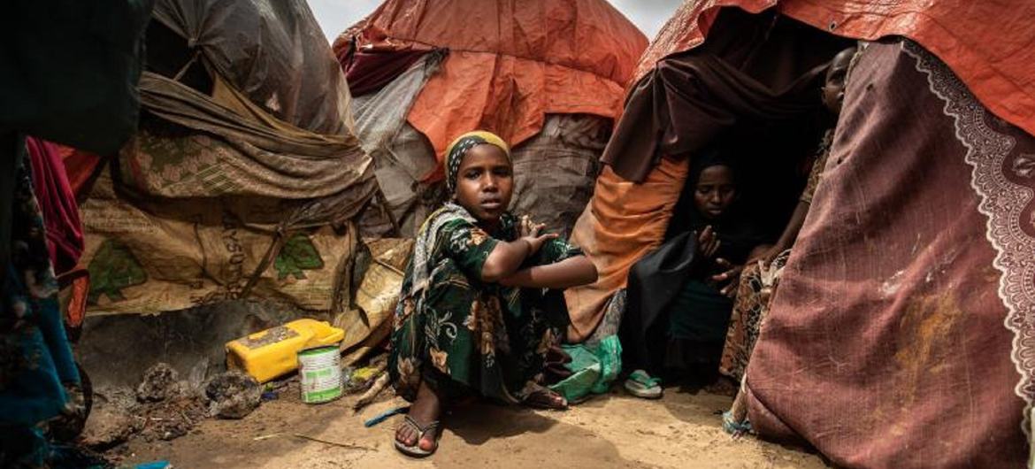 A young girl sits outside the tent her family are living in at a camp for internally displaced people in Mogadishu, Somalia in October 2022.