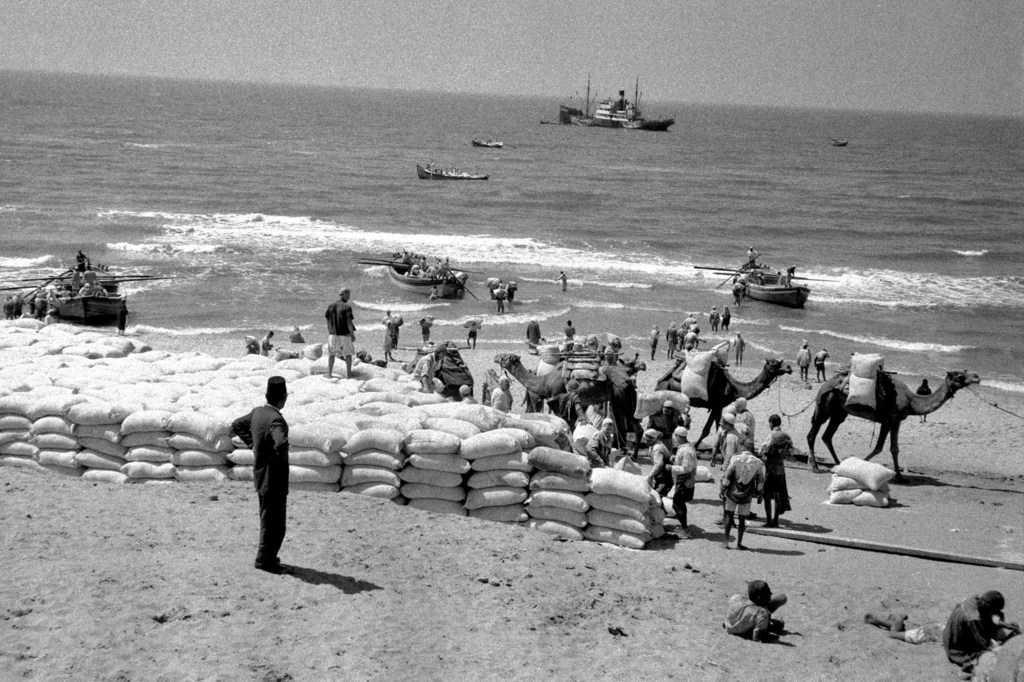 Refugiados descargan sacos de harina de un carguero en una playa cerca de Gaza, poco después de la llegada de la Fuerza de Emergencia de la ONU en 1957.