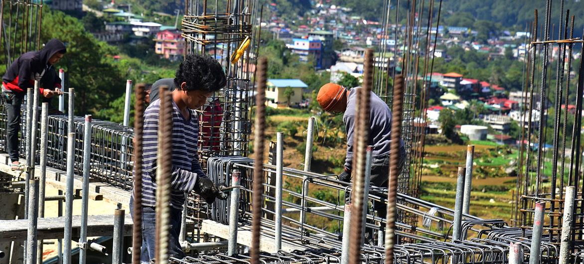 Trabajadores de la construcción levantan un edificio en Tublay, Filipinas.