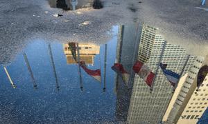 A reflection of flags being raised at UN Headquarters in New York.
