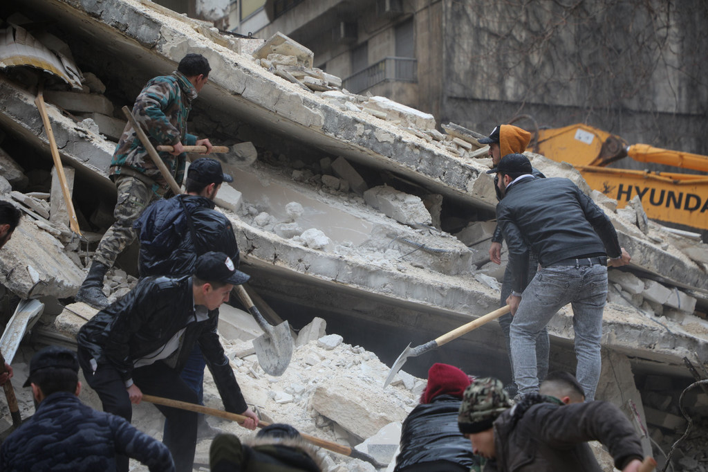 Rescuers search for survivors under the rubble in the Al-Aziziyeh neighborhood of Aleppo, Syria.