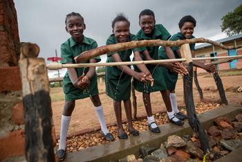 Estudantes lavam as mãos em um ponto de lavagem de mãos recém-construído em uma escola primária no distrito de Pemba, Zâmbia.
