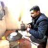 अब्दुल मजीद, पशुओं के चारे से, अपने परिवार के लिए रोटी बनाते हुए. आग चलाने के लिए लकड़ियाँ भी युद्ध में ध्वस्त हुईं इमारतों में से एकत्र की गई हैं.
