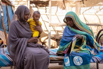 Una madre con su hija de 9 meses recibe apoyo de una concejal en el estado de Kassala, Sudán.