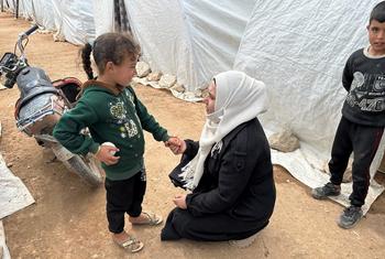 عائشة طعمة منسقة العمل الإنساني بسوريا مع فريق الباحثين الميدانيين للشؤون الإنسانية، تتحدث مع طفلة في مخيم كمونة للنازحين في سرمدا بريف إدلب.