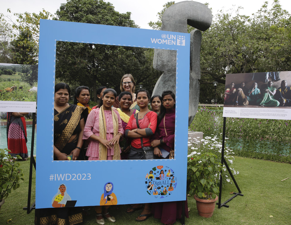 UN Women India प्रतिनिधि सुसान फर्ग्यूसन एक कार्यक्रम में नीले रंग के फोटो फ्रेम के भीतर महिला उद्यमियों के एक समूह के साथ पोज दे रही हैं।