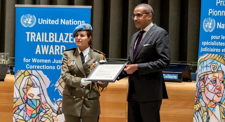 الرائدة أحلام دوزي لحظة تسلمها جائزة الأمم المتحدة الرائدة التي تمنح للموظفات العاملات في مجال العدالة والمؤسسات الإصلاحية من رئيس ديوان الأمين العام للأمم المتحدة إيرل كورتيناي راتراي.