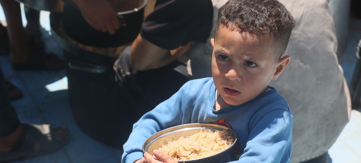 A gaza boy has a rice plate. A gaza boy has a rice plate.