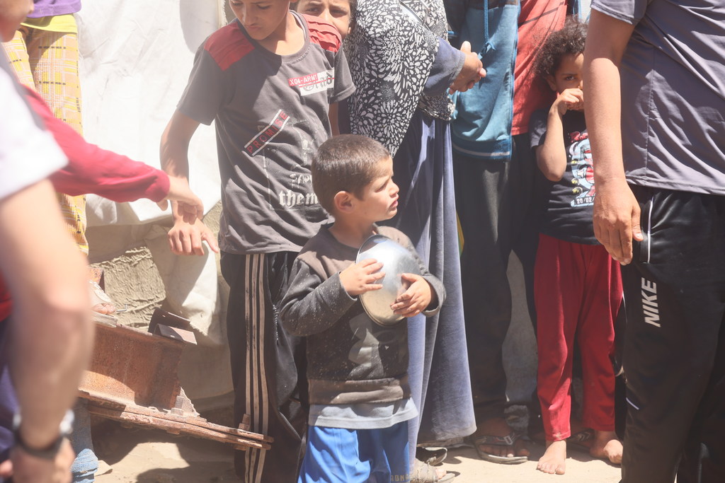 Un enfant à Gaza portant une assiette vide.
