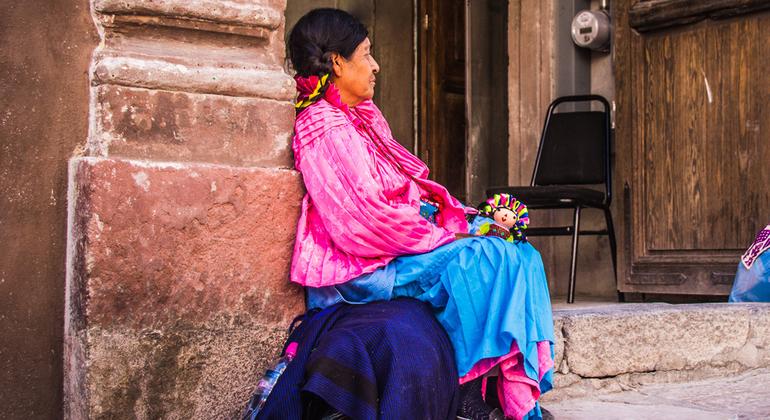 Una mujer indígena vende muñecas en las calles de Santiago de Querétaro, en México.