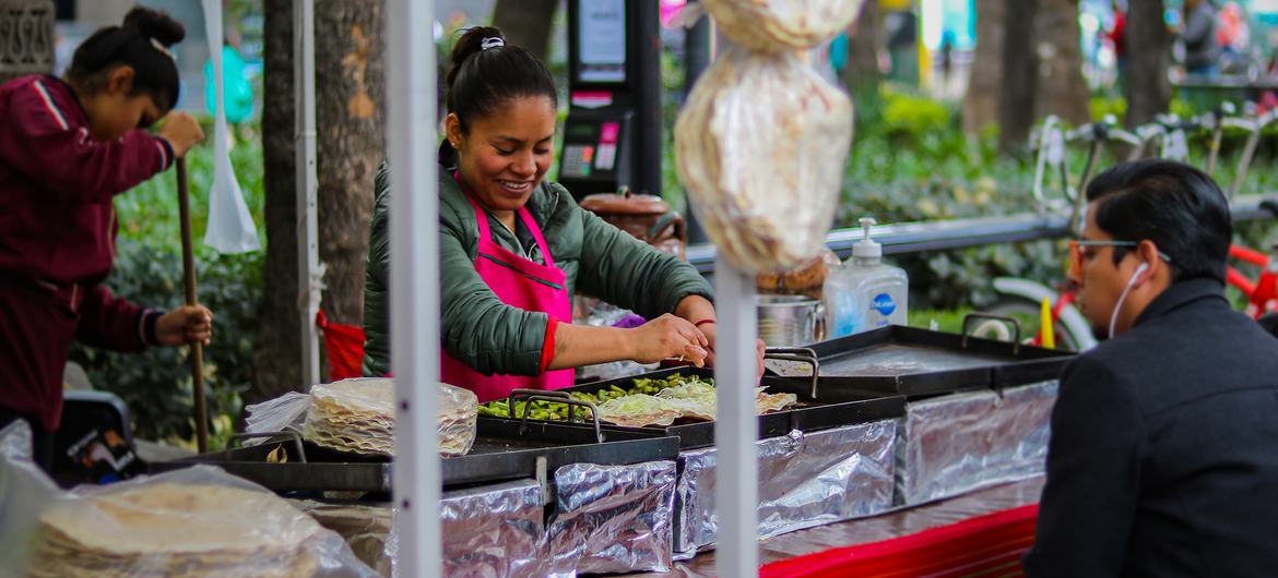 Una mujer prepara comida artesanal en un mercado callejero en el Paseo De La Reforma, Ciudad de México, México.