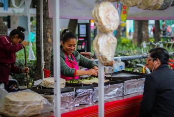 Una mujer prepara comida artesanal en un mercado callejero en el Paseo De La Reforma, Ciudad de México, México.