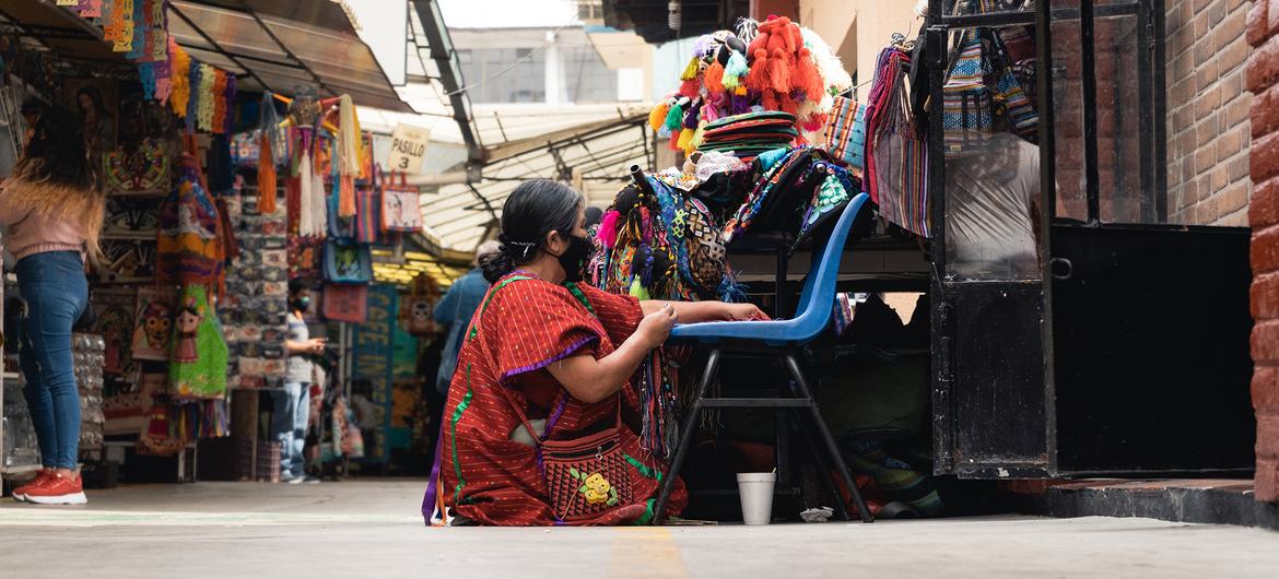 Una mujer sentada trabajando en un mercado en la Ciudad de México, México.