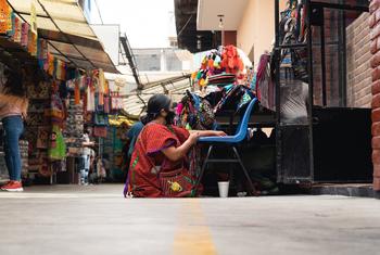 Una mujer sentada trabajando en un mercado en la Ciudad de México, México.