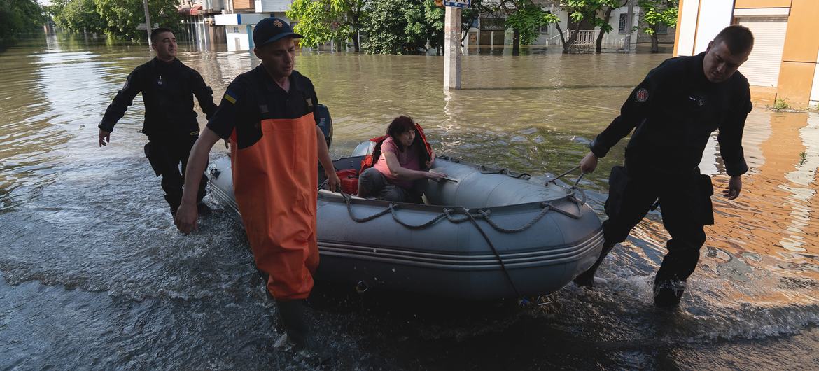 A woman is evacuated from a flooded Kherson neighbourhood after the destruction of the Kakhovka dam in southern Ukraine.