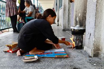 A displaced girl cooking in one of UNRWA shelters in Gaza.