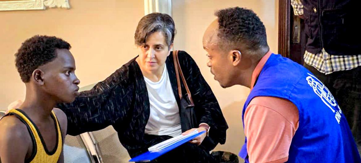 نجوى مكي، رئيسة فرع الاتصالات الاستراتيجية لدى مكتب تنسيق الشؤون الإنسانية تتحدث مع شاب في مركز المنظمة الدولية للهجرة للمهاجرين في عدن.