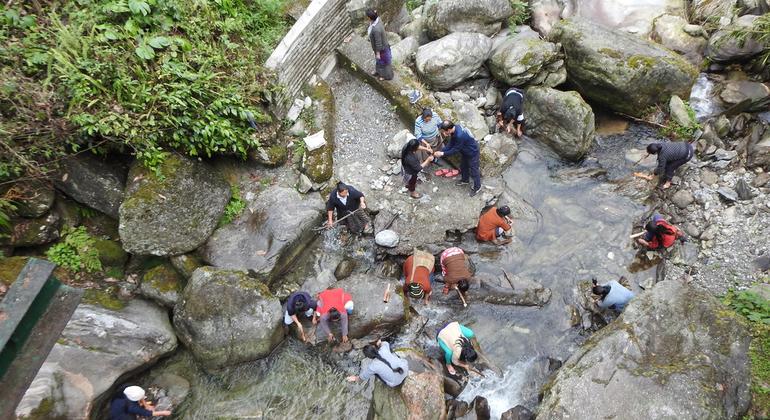 समुदाय के सदस्य, बिच्छुआ घास के रेशों को नदी में धो रहे हैं. इनसे कपड़ा निर्माताओं के लिए उच्च गुणवत्ता वाले बिछुआ फाइबर का उत्पादन किया जाता है.