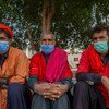 Hombres sentados en la acera en Pakistán esperando ser contratados para trabajar.