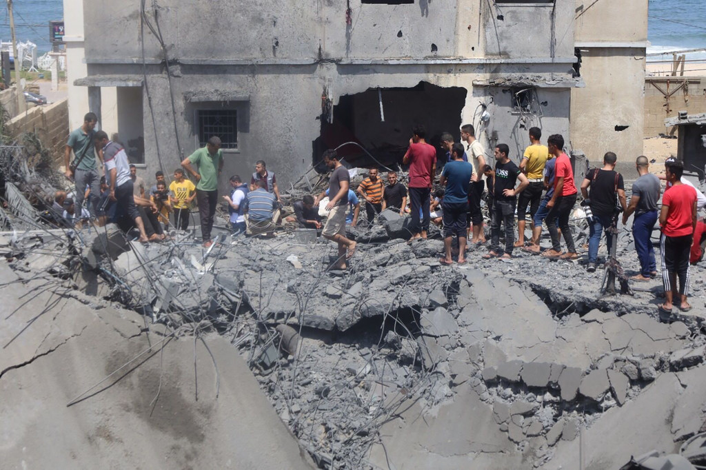 فلسطينيون يقفون على ركام منزل مدمر في غزة. 07 آب/أغسطس 2022.