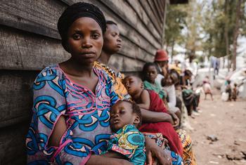 Une mère attend que sa fille fasse l'objet d'un dépistage nutritionnel dans un site de déplacés au Nord-Kivu, en République démocratique du Congo.