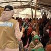 Mfanyakazi UN Women akizungumza na kundi kubwa la wanawake waliokusanyika katika eneo la uthibitishaji huko El Bohouth, Kassala, Sudan, kama sehemu ya mradi wa SHF.