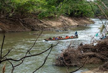 Niños migrantes cruzan un río en una embarcación en Panamá.