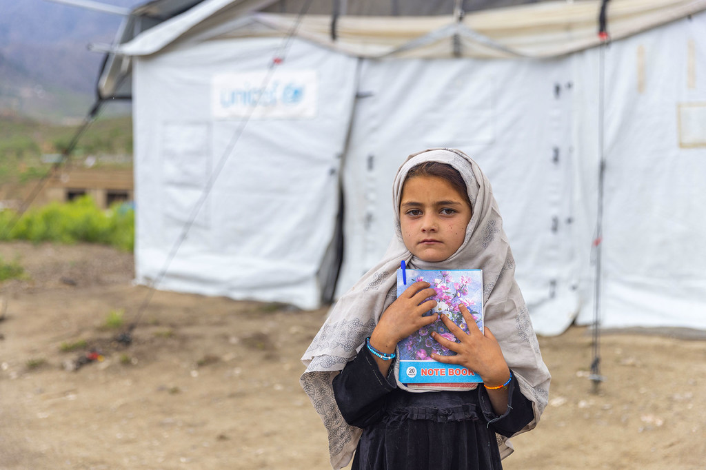 Une jeune fille se tient à l'extérieur d'un espace ami des enfants créé pour aider les enfants à surmonter leurs traumatismes après le tremblement de terre de juin 2022 en Afghanistan.