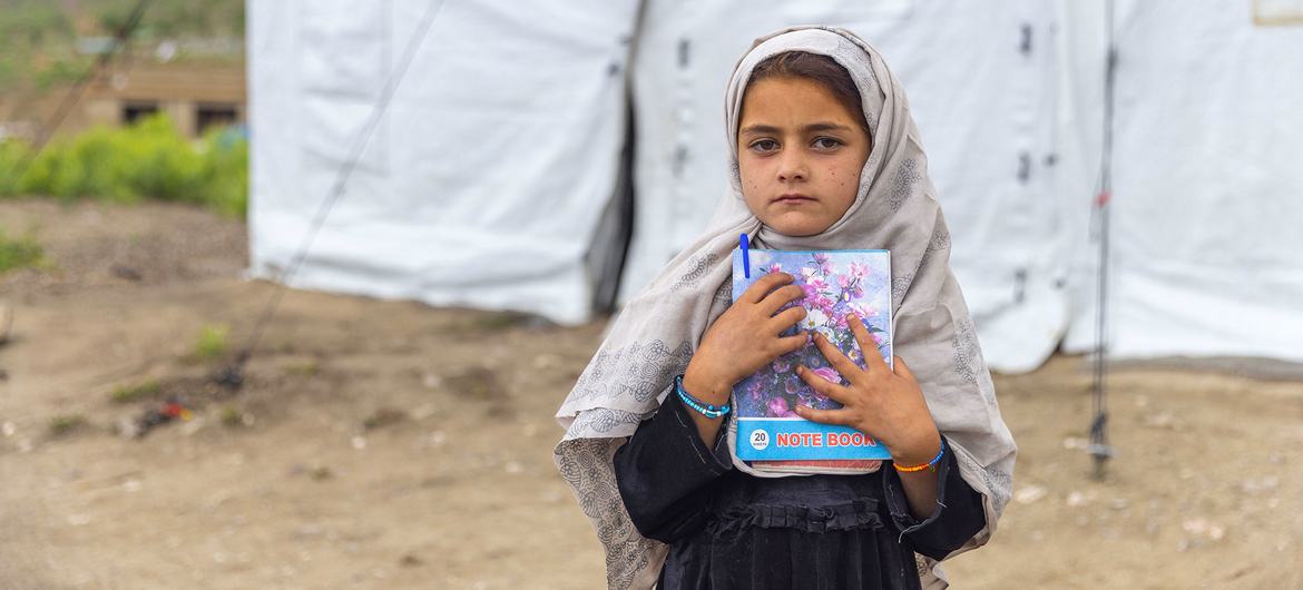 A young girl stands outside a child-friendly space created to help children cope with the trauma they experienced after the June 2022 earthquake in Afghanistan.