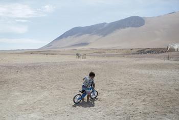 A child rides his bicycle outside a UNICEF-supported humanitarian camp for migrant families in Chile.