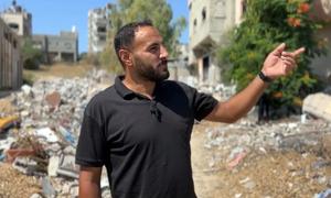 Northern Gaza resident Ahmed Abu Aita gestures towards his house in northern Gaza which has been reduced to rubble.