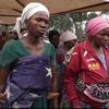 Wanawake waliokimbia makazi yao katika kambi ya Rusayo huko Kivu Kaskazini, Jamhuri ya Kidemokrasia ya Kongo, mmoja akiwa amebeba mtoto na mwingine akiwa amevaa koti jekundu.