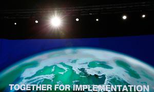 A video screen in the main COP27 plenary room displays the official slogan of the Egyptian Presidency: ‘Together for Implementation’.