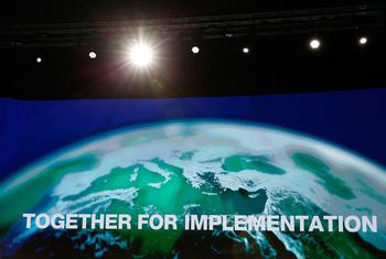 第27届联合国气候变化大会全体会议现场的屏幕上显示着主席国埃及的官方标语“共同落实”。 