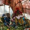 Une femme allaite son bébé de deux semaines dans la petite tente où elle et ses neuf enfants se sont réfugiés dans un site pour personnes déplacées dans la province du Nord-Kivu en RDC.