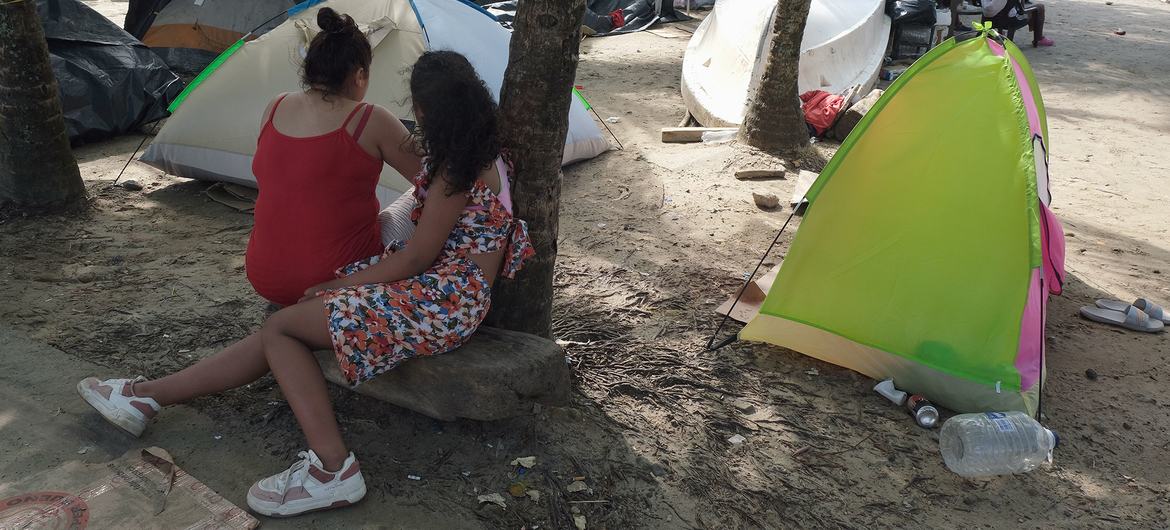 Familias se preparan para cruzar el campamento de la selva del Darién en la playa de la ciudad colombiana de Necoclí.