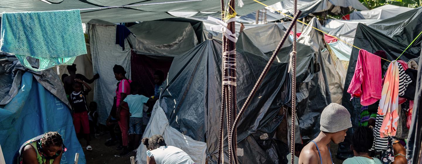  太子港让-玛丽-塞萨尔学校流离失所者营地内喷泉旁的日常生活场景。