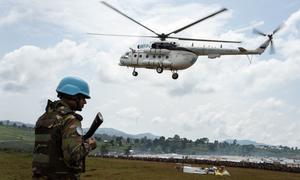 A MONUSCO peacekeeper stands guard as a UN helicopter delivers aid to an IDP camp near Ituri, Democratic Republic of the Congo. (file photo)