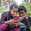 ग्वाटेमाला में दो बच्चे ऑनलाइन मंचों पर खेलों का आनन्द लेते हुए, और उनके माता-पिता ऑनलाइन सुरक्षा के विषय में एक वर्कशॉप में हिस्सा ले रहे हैं.