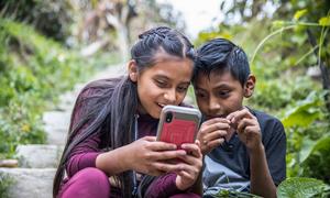 Two children play outside while their parents participate in a workshop about online security in Guatemala.